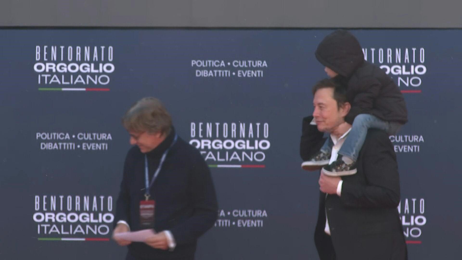 Elon Musk arriving at PM Meloni's party political rally with his young son