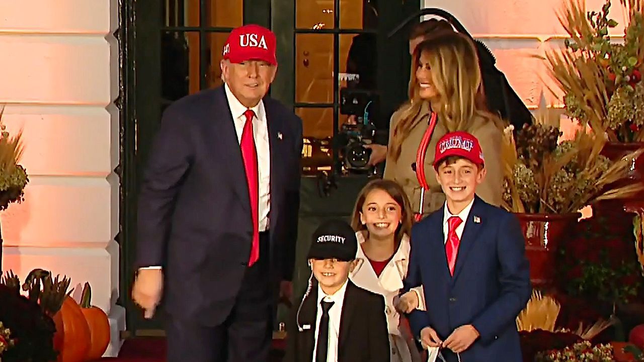 Trump and Melania hand out candy to 'mini-Trump' at White House Halloween celebration