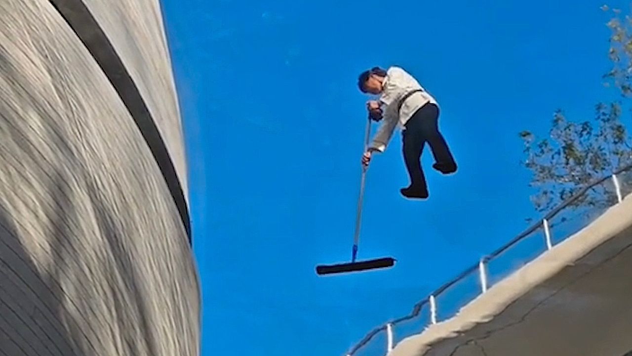 Baffling moment worker appears to float in midair while cleaning