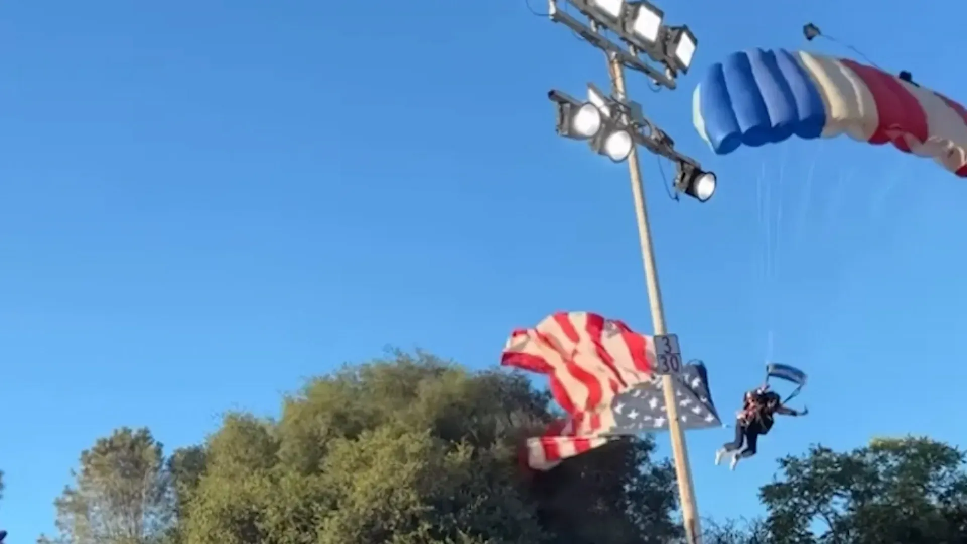 Video: Fallschirmspringer stürzt ab, nachdem sich bei der Landung eine US-Flagge in einem Baum verfängt