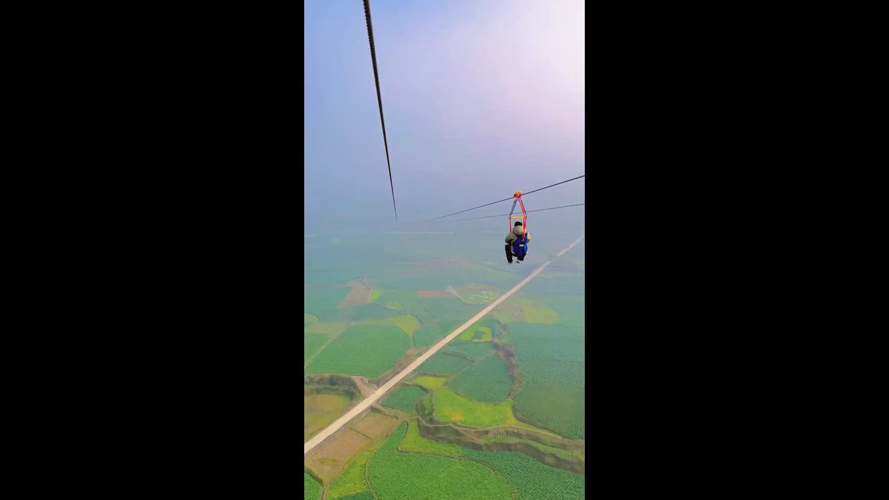 Video: China: Chinesische Touristen flogen auf extremer Seilrutschen-Attraktion über Reisfelder auf dem Land